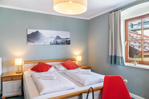 a bedroom with a bed with white and red pillows at Chalet Sonneck - Seefeld in Seefeld in Tirol