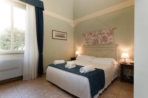 a bedroom with a bed with towels on it at Borgo San Martino - Residence Hotel & SPA in Riparbella