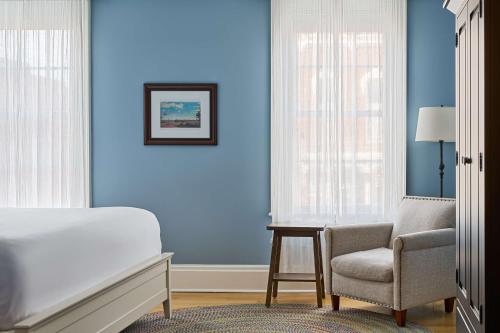 a bedroom with blue walls and a bed and a chair at The Cadillac House Lexington, Tapestry Collection By Hilton in Lexington