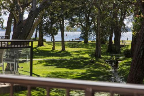 a view of a park with trees and a pond at 'Bay Parklands' Close to Waters Edge in Nelson Bay