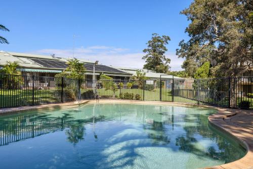 a swimming pool in front of a fence at 'Bay Parklands' Close to Waters Edge in Nelson Bay