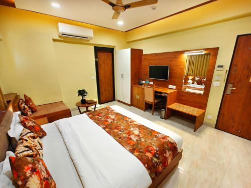 a bedroom with a bed and a desk with a computer at Opulence Inn - 500 Meters From Railway Station in Udaipur