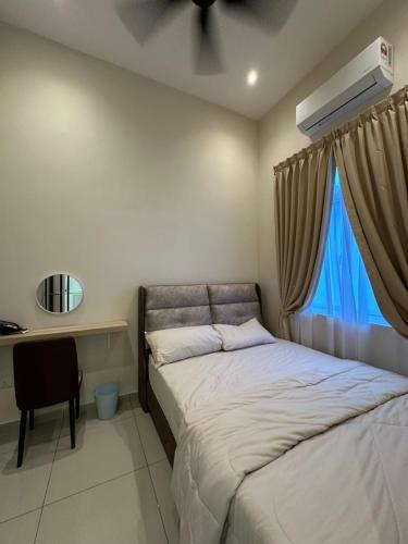 a bedroom with a bed and a desk and a window at De Home Kluang Homestay in Kluang