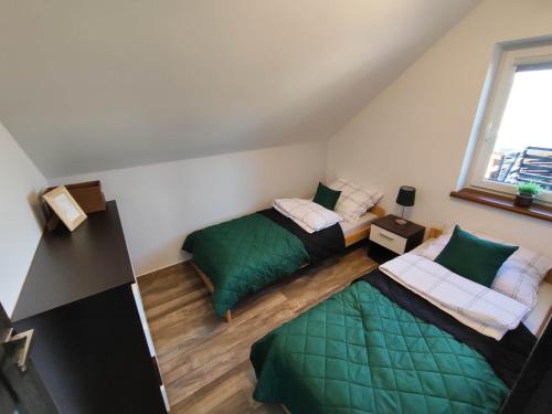 a room with two beds and a window at Apartament Widokówka in Hoczew