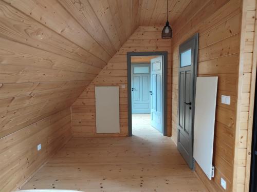 a hallway in a wooden house with two doors at Dzika Dziura z jacuzzi in Zawoja