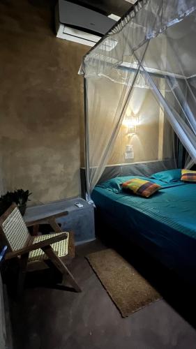 a bedroom with a canopy bed and a chair at Kataragama Homestay in Kataragama