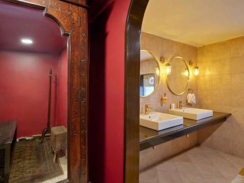 a bathroom with two sinks and a mirror at juSTa Diwans Bungalow in Ahmedabad