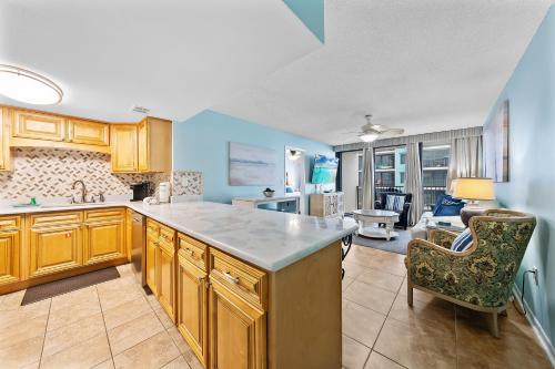 cocina con armarios de madera y sala de estar. en Island Winds West 471, en Gulf Shores