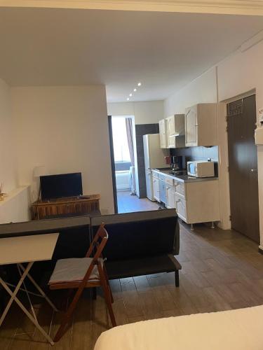un salon avec un canapé et une cuisine dans l'établissement Studio cosy en centre d'Ajaccio, à Ajaccio