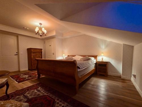 a bedroom with a bed and a chandelier at Laxå Herrgårdshotellet in Laxå