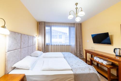 a bedroom with a large bed and a tv at SPA complex Elena in Elena