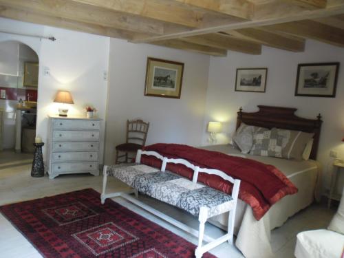 a bedroom with a bed with a bench in it at Bergerie de Lagarrigue in Baladou