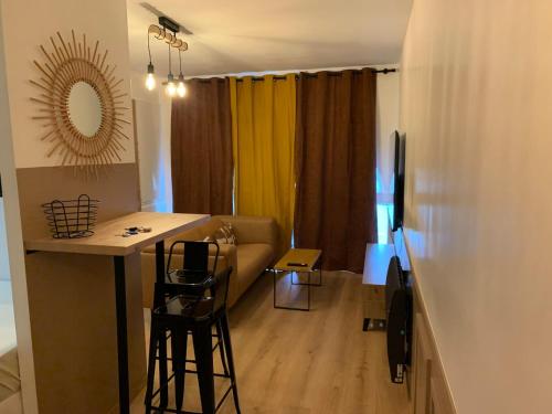 un salon avec un canapé, une table et des chaises dans l'établissement Studio moderne, à Pau