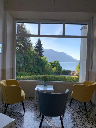 a room with a large window with a table and chairs at Hotel Loveno in Menaggio