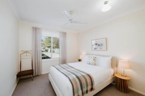 a white bedroom with a bed and a window at Jewel on Lewis - Central Mudgee Haven near Wineries in Mudgee
