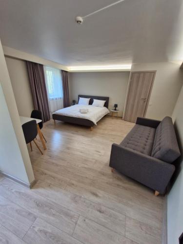 a living room with a bed and a couch at Trevena Kretinga in Kretinga