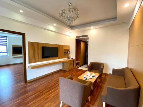 a living room with a dining table and a television at Muong Thanh Quy Nhon Hotel in Quy Nhon