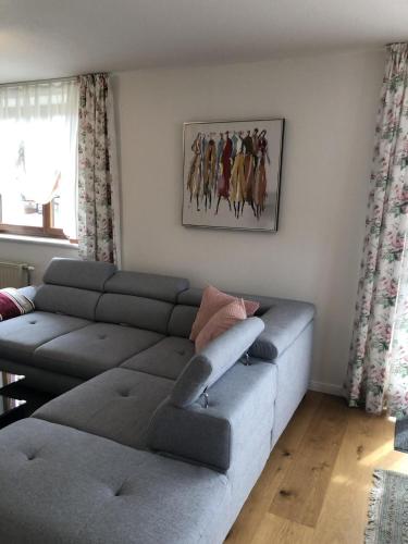 a living room with a couch and a horse painting on the wall at Ferienwohnung am Sonnenweg in Admont