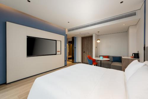 a hotel room with a large bed and a flat screen tv at Holiday Inn Express Shangrao Railway Station by IHG in Shangrao