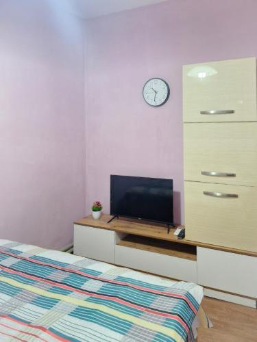 a bedroom with a bed and a dresser with a tv at Elite Capsule Hotel in Balqash