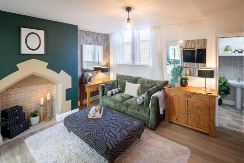 a living room with a green couch and a fireplace at Character, Comfort and Convenience, No 5 Rosedene Mews in Marske-by-the-Sea