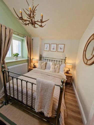 a bedroom with a bed and a chandelier at Gable Cottage - Staindrop - Copper Bath - Logburner in Staindrop