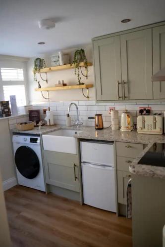 a kitchen with a sink and a washing machine at Gable Cottage - Staindrop - Copper Bath - Logburner in Staindrop