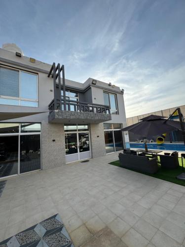 a large house with a patio and a pool at Natalie water park chalet in Al Kafrayn