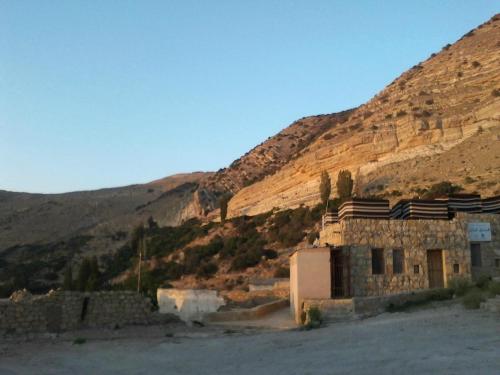 an old building in the middle of a mountain at Wadi Dana Lodge - نزل وادي ضانا in Dana