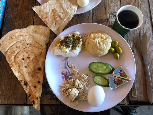 a plate of food with eggs and vegetables on a table at Wadi Dana Lodge - نزل وادي ضانا in Dana