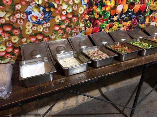 a buffet with several trays of food on a table at Wadi Dana Lodge - نزل وادي ضانا in Dana