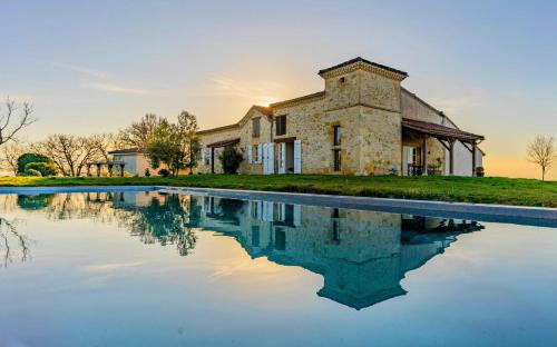 a stone house with a pool in front of it at La Colline Gersoise-Piscine-Sauna in La Sauvetat