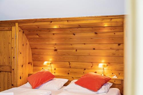 a bedroom with a wooden wall with two beds at Chalet Sonneck - Seefeld in Seefeld in Tirol