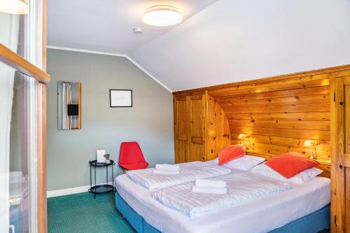 a bedroom with a large bed and red chairs at Chalet Sonneck - Seefeld in Seefeld in Tirol