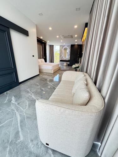 a living room with a white couch in a room at Sararin Luxury Villas in Nong Khai