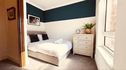 Un dormitorio con una cama y una cómoda. en Chatsworth Terrace - Chesterfield Centre and Peak District, en Chesterfield