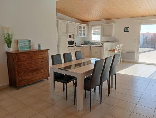 - une cuisine avec une table à manger et des chaises dans l'établissement Maison 3 étoiles près des plages 3 chambres, à Saint-Hilaire-de-Riez