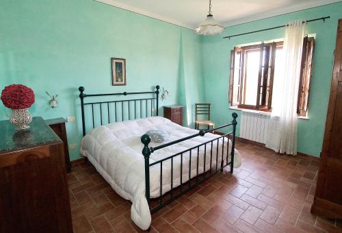 a bedroom with a bed in a room with blue walls at Agriturismo Caliano in Asciano