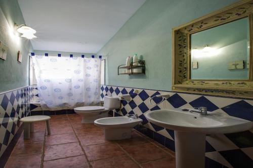 a bathroom with two toilets and a sink and a mirror at Andalusian Getaway Game of Thrones Castle in Posadas