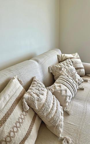 - un canapé avec des oreillers dans l'établissement Superbe Studio plein centre de Juan les pins 500m des plages, à Antibes