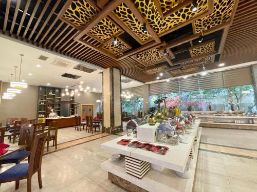 a dining room with a table with plates of food at Muong Thanh Grand Xa La Hotel in Hanoi
