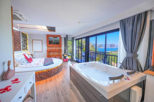a large bathroom with a large tub and a bedroom at Ramitos Hotel in Turunc