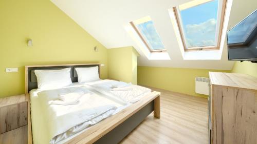 a bedroom with a large bed with two windows at Blue Mare, Sun & Snow in Łukęcin
