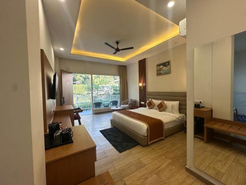 a bedroom with a bed and a ceiling fan at Creek Nest Resort in Rāmnagar
