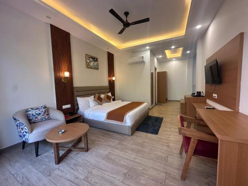 a hotel room with a bed and a couch and a table at Creek Nest Resort in Rāmnagar