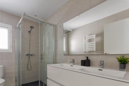 a bathroom with a shower and a sink and a mirror at Villa Boutique Can Plana in Sant Jordi
