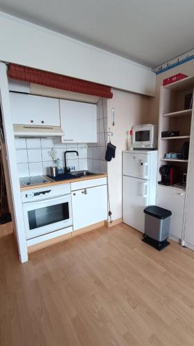 une petite cuisine avec une cuisinière et un micro-ondes dans l'établissement Au Bord de Mer, à Saint-Malo