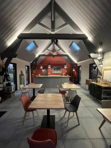 un restaurant avec des tables et des chaises dans une salle dans l'établissement Les Caminols, à La Dornac
