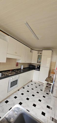 a kitchen with white cabinets and a black and white tile floor at Casa Carlo in Chia
