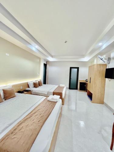 a large room with two beds and a couch at Gia Phú Hotel Bình Thuận in Tánh Linh